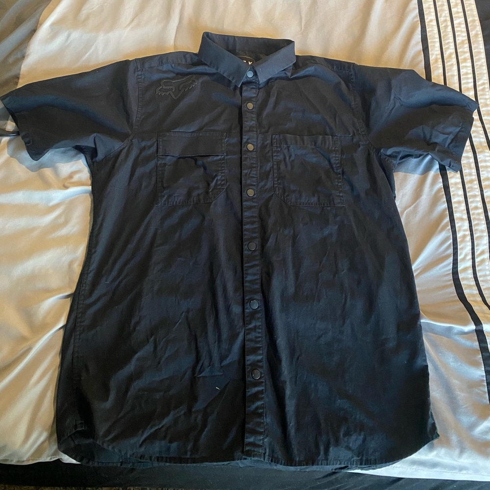 Mens black Fox button down short sleeve w/rubber fox logo on right shoulder.